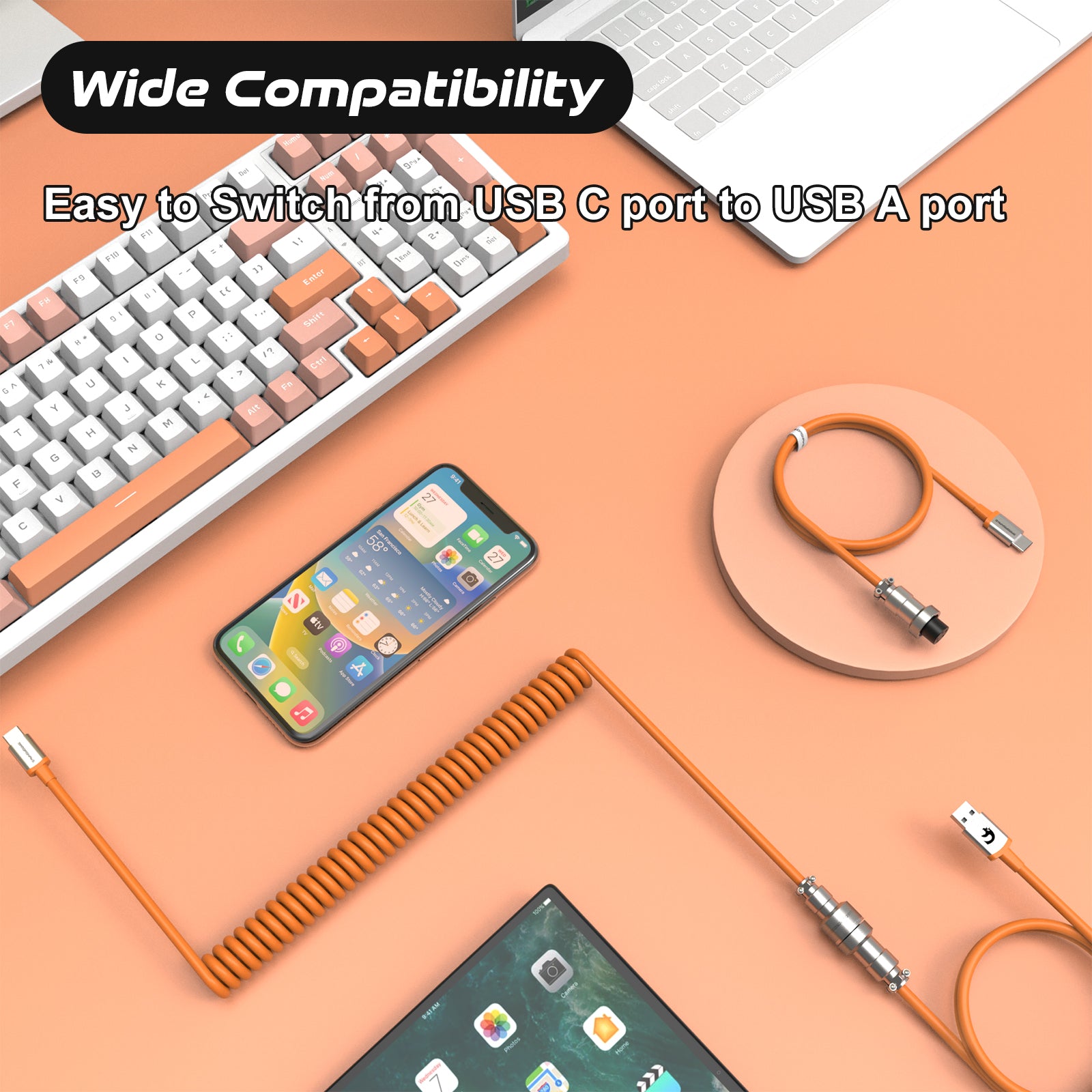 Orange coiled USB-C cable with metal aviation connector, connected to a keyboard and phone